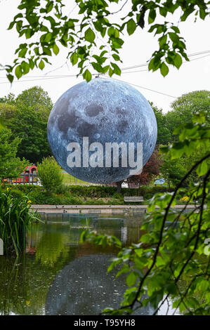 Brighton Regno Unito 30 aprile 2019 - un grande modello di la luna sorge al di sopra del Queens Park stagno in Brighton questa mattina pronto per tonights Brighton Festival evento 'Museum della Luna" da Luke Jerram . La luna sarà illuminato di sera e durante il fine settimana, accompagnata dalla musica del compositore Dan Jones come si festeggia 50 anni poiché il famoso sbarco sulla luna. Credito: Simon Dack / Alamy Live News Foto Stock