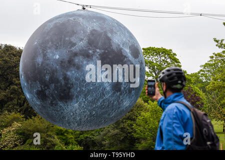 Brighton Regno Unito 30 aprile 2019 - un grande modello di la luna sorge al di sopra del Queens Park stagno in Brighton questa mattina pronto per tonights Brighton Festival evento 'Museum della Luna" da Luke Jerram . La luna sarà illuminato di sera e durante il fine settimana, accompagnata dalla musica del compositore Dan Jones come si festeggia 50 anni poiché il famoso sbarco sulla luna. Credito: Simon Dack / Alamy Live News Foto Stock