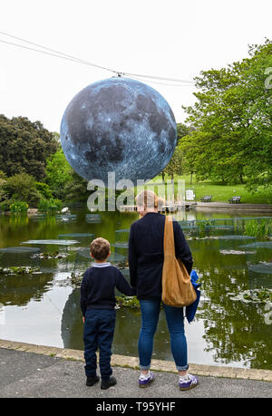 Brighton Regno Unito 30 aprile 2019 - un grande modello di la luna sorge al di sopra del Queens Park stagno in Brighton questa mattina pronto per tonights Brighton Festival evento 'Museum della Luna" da Luke Jerram . La luna sarà illuminato di sera e durante il fine settimana, accompagnata dalla musica del compositore Dan Jones come si festeggia 50 anni poiché il famoso sbarco sulla luna. Credito: Simon Dack / Alamy Live News Foto Stock