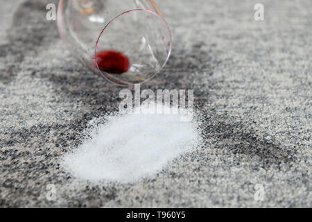 Osterode am Harz in Germania. 16 Maggio, 2019. Illustrazione - un bicchiere con poco vino rosso si trova su un tappeto accanto a macchie su cui sale è stata spruzzata. Frank Maggio/picture alliance Credit: Frank Maggio/picture alliance/dpa/Alamy Live News Foto Stock