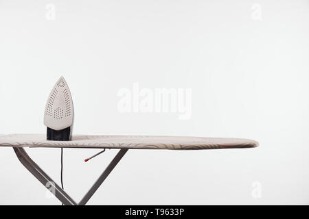 Asse da stiro con gambe scuro e ferro isolato su grigio Foto Stock