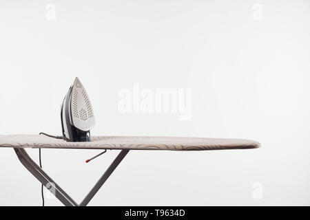 Asse da stiro con gambe scuro e ferro isolato su bianco Foto Stock