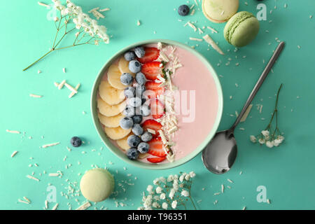 Ciotola con rosa di yogurt e frutta fresca sul colore di sfondo Foto Stock