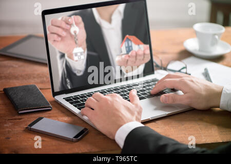 Aziendali di man mano sul tavolo utilizzando un computer portatile con gli investimenti immobiliari Foto Stock