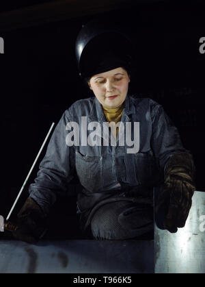 Enola O'Connell, età 32, vedova e madre di un bambino. Ex-casalinga, ora è lei la donna solo saldatore a Heil e Company, Milwaukee, Wisconsin. Sebbene l'immagine di 'Rosie la rivettatrice' riflette il lavoro industriale di saldatrici e rivettatrici, la maggior parte delle donne che lavorano riempito non-factory posizioni in ogni settore dell'economia. Cosa unificato le esperienze di queste donne è che essi hanno dimostrato a se stessi e il paese, che avrebbero potuto fare un lavoro dell uomo e potrebbe farlo bene. Fotografata da Howard R. Hollem, 1943. Foto Stock