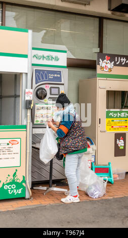 TOCHIGI, Giappone - 5 febbraio 2019: donna non identificato le bottiglie di smistamento per la bottiglia di plastica macchina di riciclaggio al di fuori di un supermercato di Tochigi. Questo mach Foto Stock