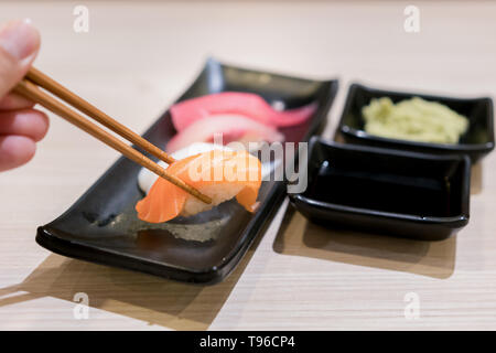 Rotolo di Sushi con salmone e fresco e mescolare insieme di sushi in lamiera nera - il cibo giapponese impostare lo stile al ristorante giapponese. Foto Stock