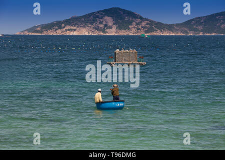 Pescatore vietnamita nel suo canestro galleggiante, Vinh Hy, Vietnam Asia Foto Stock