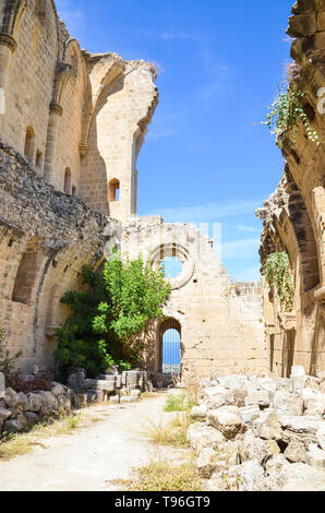 Resti delle mura della splendida abbazia Bellapais in Bellapais, la parte settentrionale di Cipro. Il monastero storico nella parte turca dell'isola catturato con cielo blu su una fotografia in verticale. Attrazione popolare. Foto Stock