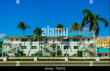 Grand Cayman, Isole Cayman, agosto 2018, facciata di una spiaggia caraibica resort visto dalla strada Foto Stock