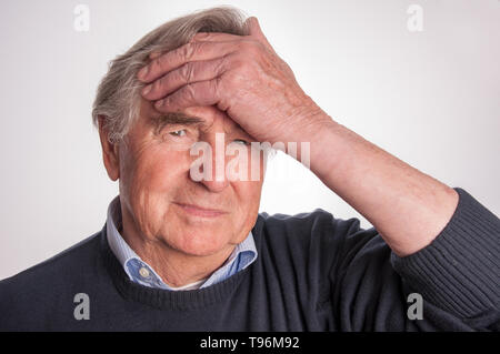 Senior man aventi mal di testa isolata su sfondo bianco Foto Stock