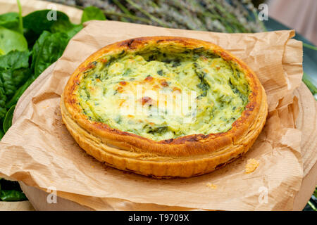 Close-up di quiche con verdure fresche. Sfondo in toni di verde. Rustico e aspetto del paese. Foto Stock