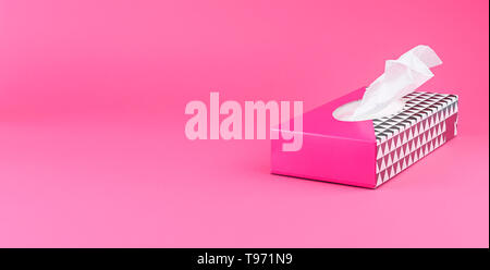 Tovaglioli di carta in un riquadro rosa su uno sfondo semplice. Spazio libero per il testo. Spazio di copia Foto Stock