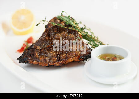 Grigliata di passera pianuzza (sogliola pesce) con limone, erbe e salsa appetitosa Foto Stock