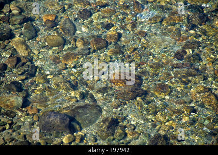 Rocce e ciottoli visto attraverso lo strato trasparente di acqua cristallina Foto Stock
