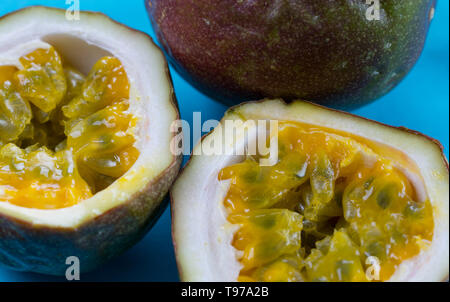 Affettato e tutta la viola il frutto della passione su un turchese brillante background Foto Stock