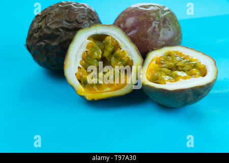 Affettato e tutta la viola il frutto della passione su un turchese brillante background Foto Stock