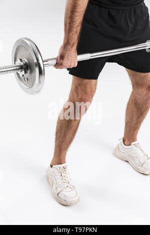 Immagine ritagliata di un sport giovane uomo fitness isolare oltre il muro bianco sullo sfondo fare esercizi con barbell. Foto Stock