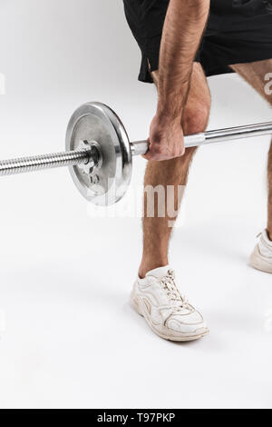 Immagine ritagliata di un sport giovane uomo fitness isolare oltre il muro bianco sullo sfondo fare esercizi con barbell. Foto Stock