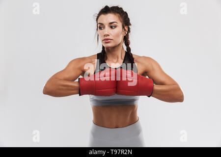 Foto di una giovane e bella incredibile forte sport fitness boxer donna in posa isolate su muro bianco sullo sfondo fare esercizi con i guanti. Foto Stock