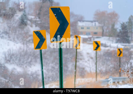 Indicazioni della strada contro un paesaggio innevato Foto Stock