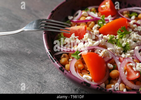 Gustosa insalata con i ceci in una terrina sulla tabella grigia Foto Stock