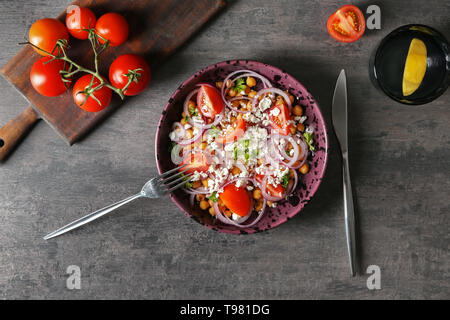 Gustosa insalata con i ceci in una terrina sulla tabella grigia Foto Stock