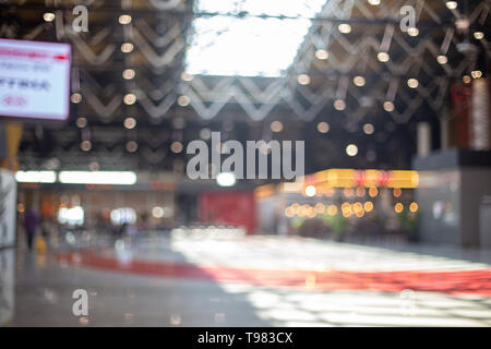 Sfocato bellissimo sfondo bokeh di fondo: persone sfocate, viaggiatore silhouette è camminare in aeroporto sala partenze Foto Stock