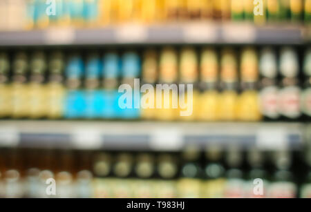 Vista offuscata assortiti di alcolici su scaffali in negozio Foto Stock