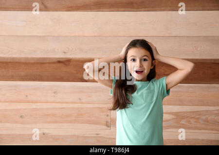 Ragazza emotiva su sfondo di legno Foto Stock