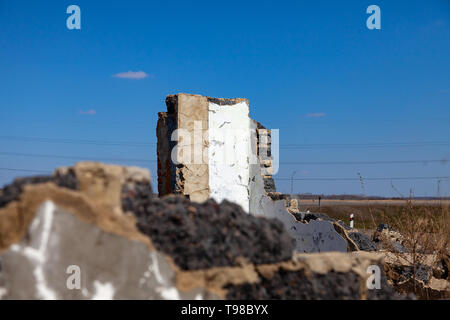 Abbandonato e distrutto edificio dal quale solo i resti di mura e scoperchiata pareti con spazzatura e detriti di costruzione. Le conseguenze del bom Foto Stock