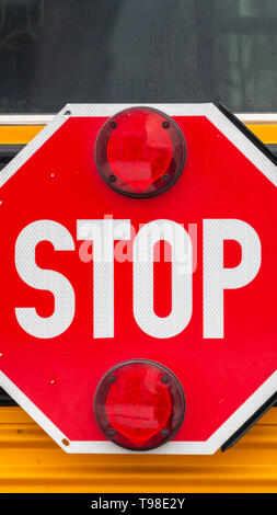 Cancellare verticale fino in prossimità di un ottagono rosso a forma di stop con luci di segnale su un bus di scuola Foto Stock