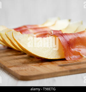 Fette di melone avvolti nel prosciutto, vista laterale. Close-up. Foto Stock