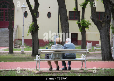 Senior coppia romantica seduto al banco nel parco, Vojvodina regione (Serbia), vicino al lago di Palic Foto Stock