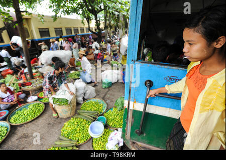 02.09.2013, Yangon, , Myanmar - una ragazza è in piedi in un treno vano della corona treno a succhiare un lecca-lecca. Il locale ferrovia suburbana network ser Foto Stock