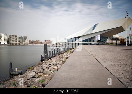 Splendide immagini lungo il fiume Amstel dei musei e la stazione centrale in sole primaverile Foto Stock