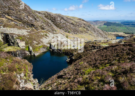 Inondati in disuso cava di ardesia pit e cumuli di scorie sul percorso di Carnedd Moel Siabod montagna nel Parco Nazionale di Snowdonia. Capel Curig Conwy Wales UK Foto Stock