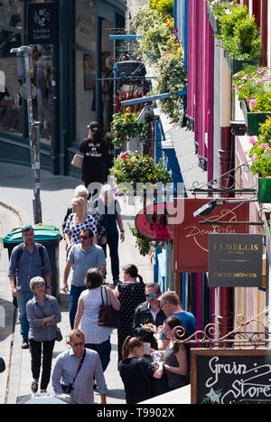 La gente a piedi lungo i negozi sulla storica Victoria Street di Edimburgo città vecchia, Scotland, Regno Unito Foto Stock