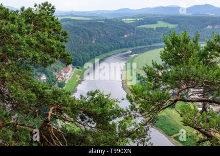 Vista aerea del fiume navigabile tra il verde dei boschi.pittoresco rami di alberi in primo piano, la nave naviga sul fiume.Case con ro rosso Foto Stock