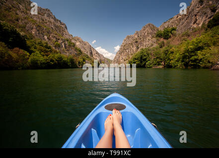 Il kayak attraverso il fiume nel canyon Matka, Macedonia. Donna gambe in kayak blu Foto Stock