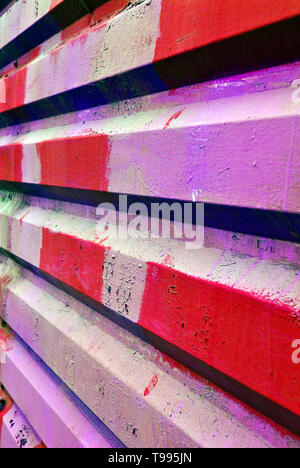 Ferro vecchio rosso, rosa, viola dipinto corrugato recinzione sfondo in prospettiva Foto Stock