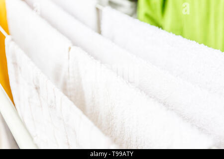 Bianche e colorate lenzuola e asciugamani per essere essiccato sul stendibiancheria. Foto Stock