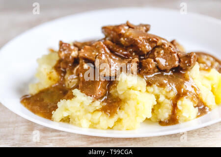 Brasato di manzo, carne di manzo stroganoff con sugo su purea di patate. Close-up, vista dall'alto Foto Stock