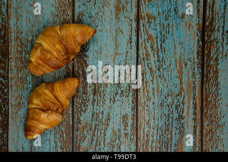 Croissant appena sfornati su un vecchio sfondo vintage. vista dall'alto, con spazio per il testo Foto Stock