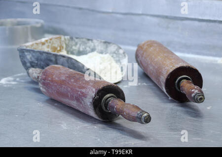 Farina e rulli sul tavolo. Preparazione di pasta al forno. Professional faktory. Foto Stock