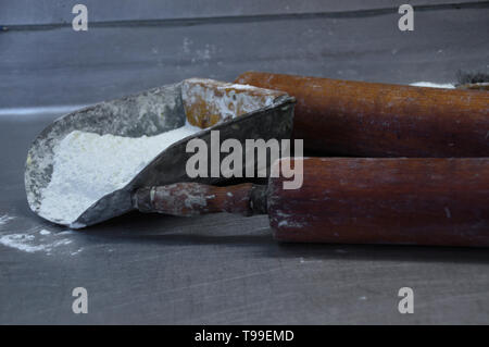 Farina e rulli sul tavolo. Preparazione di pasta al forno. Professional faktory. Foto Stock