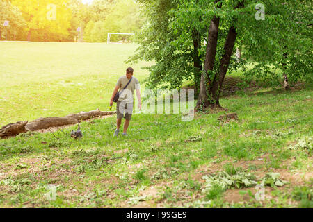 Uomo felice con il cane di godere in divertenti passeggiate all'aperto. Foto Stock