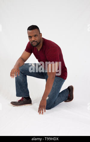 Uomo nero pensieroso inginocchiato Foto Stock