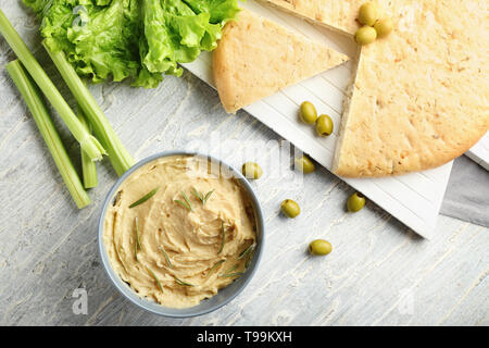 Ciotola con gustosi hummus, pane pita e olive su tavola Foto Stock