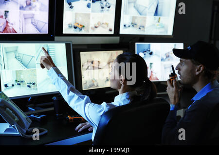 Le guardie di sicurezza monitoraggio moderne telecamere TVCC in camera di sorveglianza Foto Stock